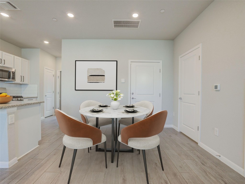 9015 Cattle Baron Path, Unit 502 Austin, TX 78747 - Photo 8 of 40 a view of a dining room with furniture and wooden floor