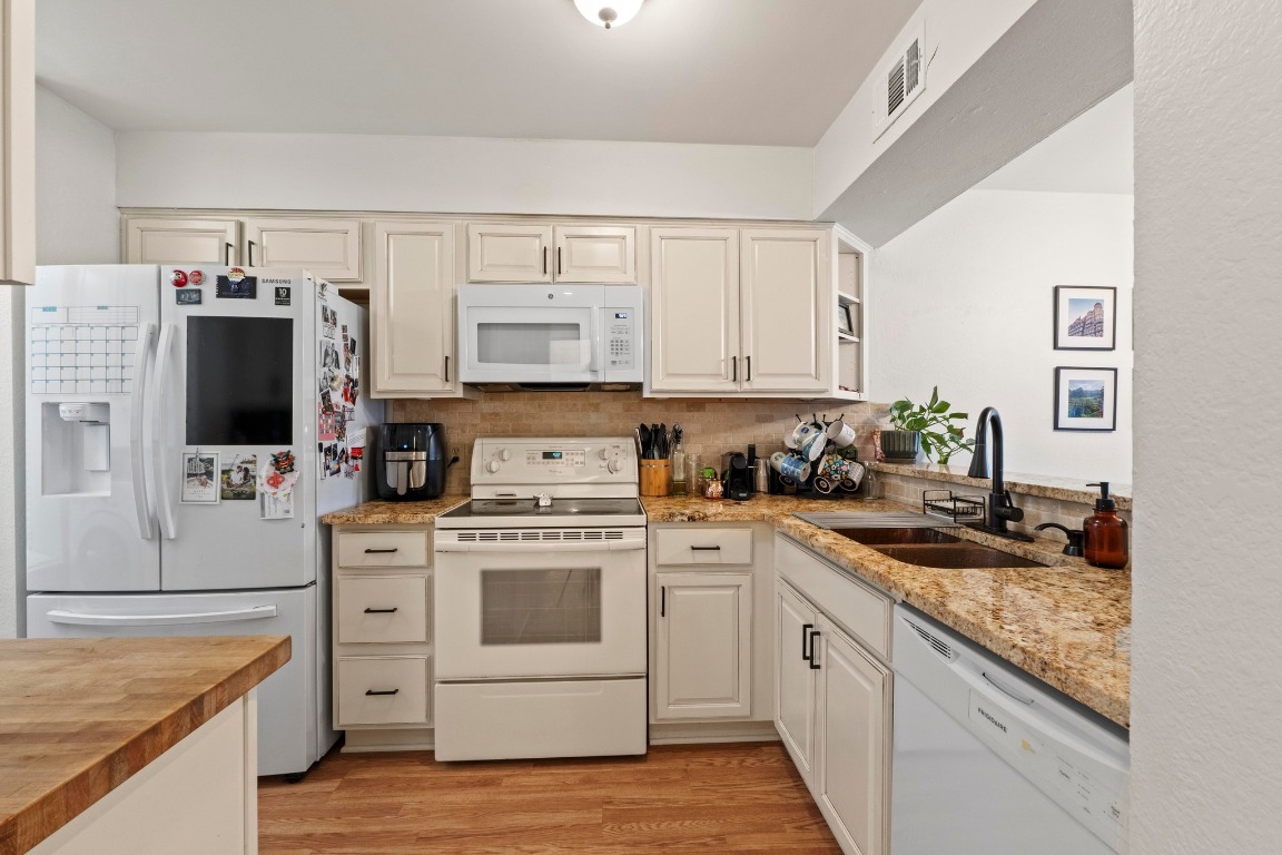 3801 Menchaca Road, Unit 5 Austin, TX 78704 - Photo 13 of 40 a kitchen with a stove a sink and a refrigerator