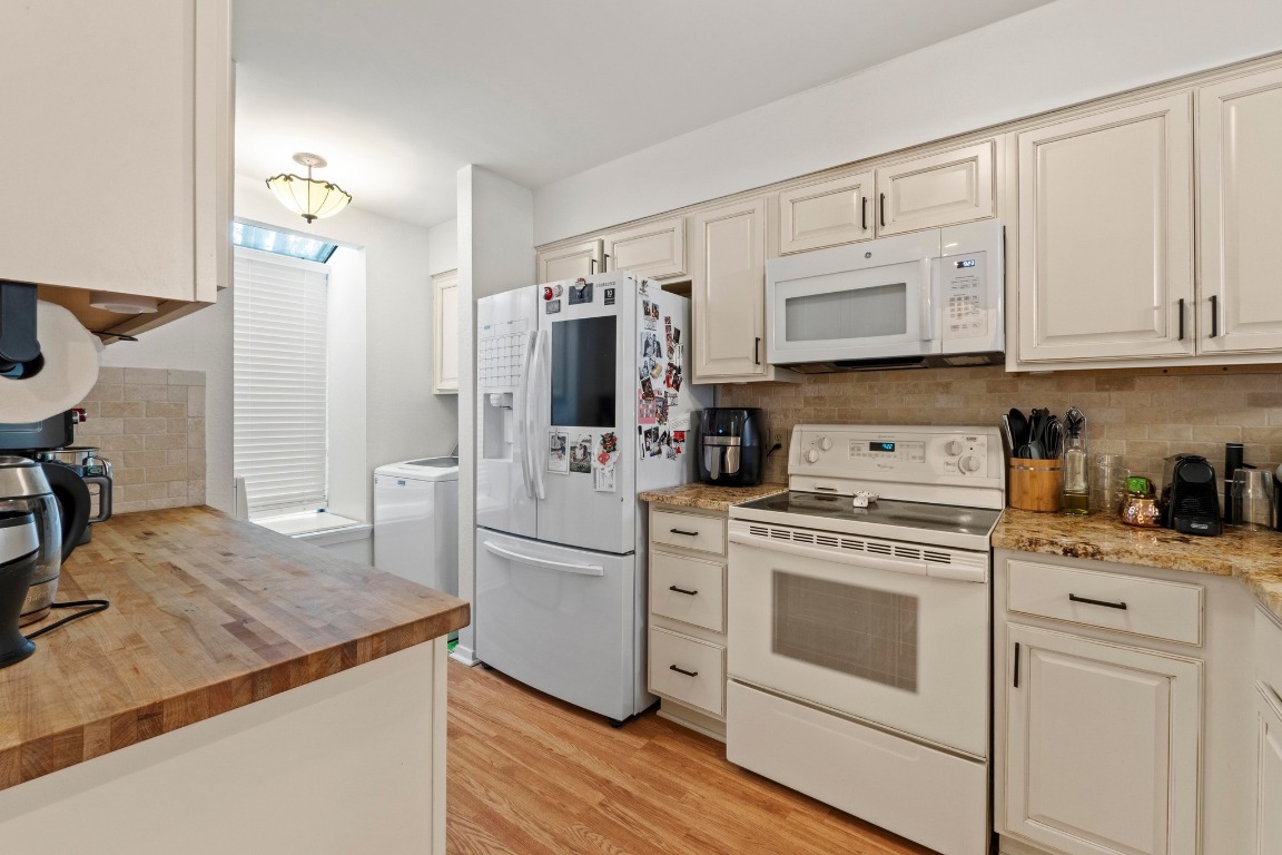 3801 Menchaca Road, Unit 5 Austin, TX 78704 - Photo 14 of 40 a kitchen with white cabinets and white appliances