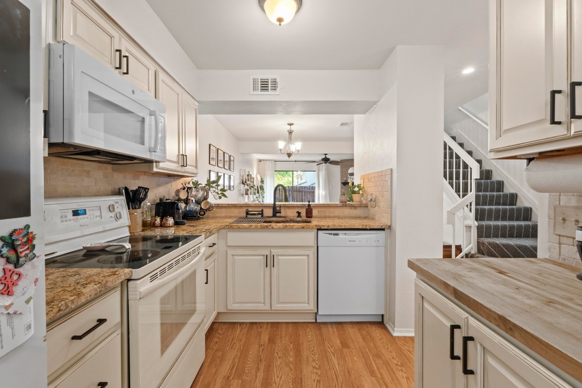3801 Menchaca Road, Unit 5 Austin, TX 78704 - Photo 16 of 40 a kitchen with granite countertop white cabinets and white appliances