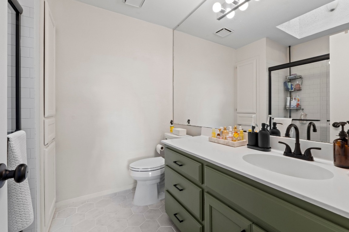 3801 Menchaca Road, Unit 5 Austin, TX 78704 - Photo 21 of 40 a bathroom with a sink a toilet and mirror