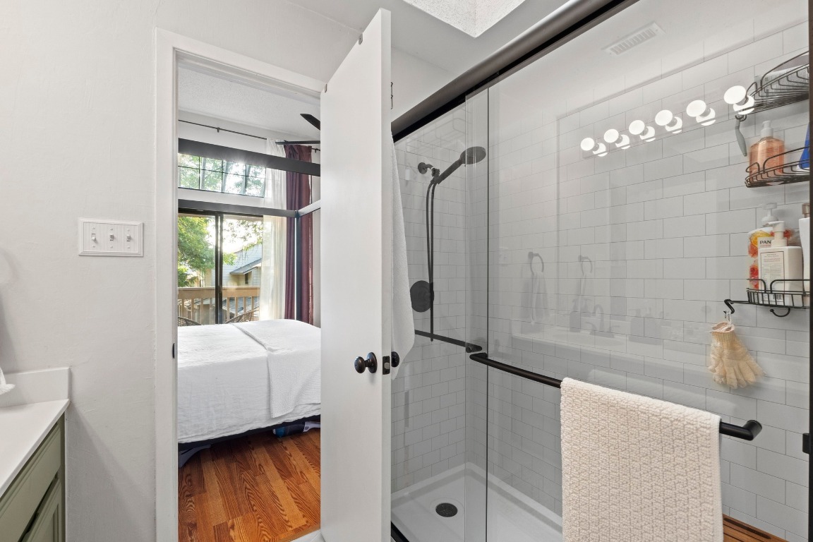 3801 Menchaca Road, Unit 5 Austin, TX 78704 - Photo 22 of 40 a en suite bathroom with a sink a mirror and a bathtub