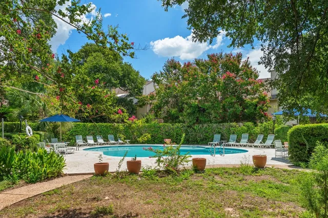 a view of a fountain in a yard with palm trees