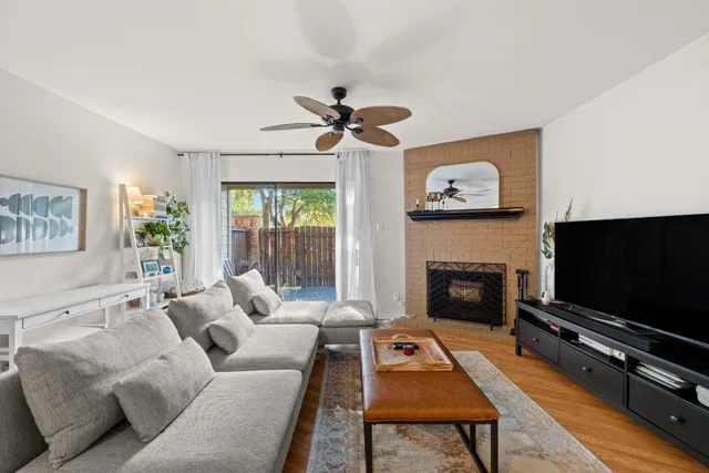 a living room with furniture a flat screen tv and a fireplace