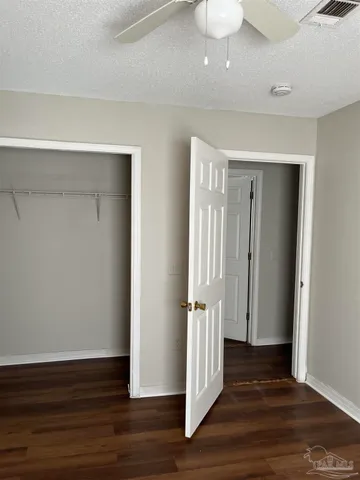 a view of a hallway with wooden floor and closet