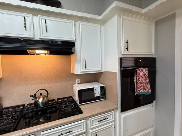 a kitchen with granite countertop a stove and a microwave