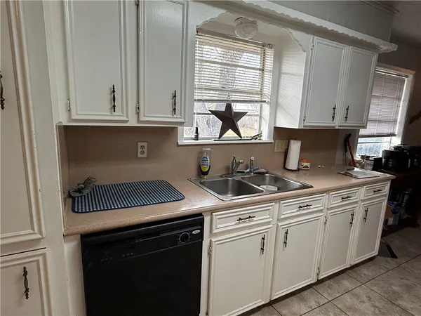 a kitchen with white cabinets and appliances