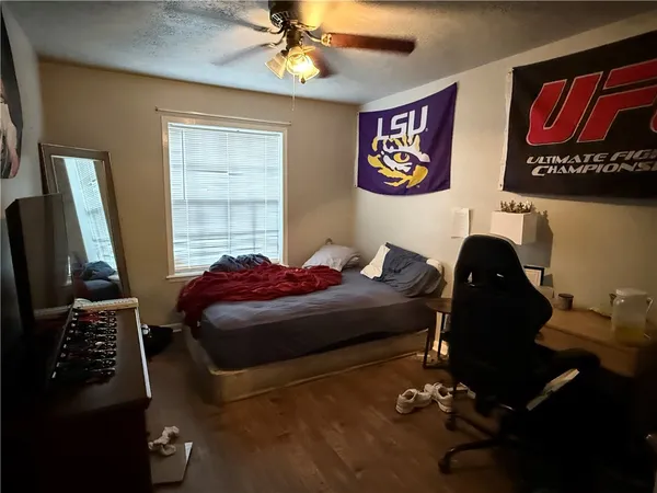 a bedroom with a bed and a flat tv screen on the dresser