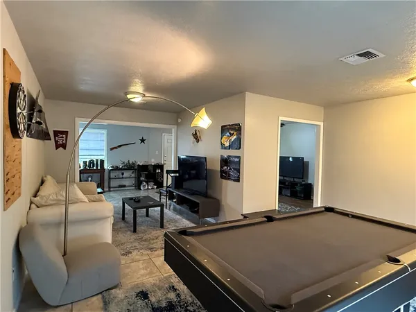a living room with furniture pool table and window