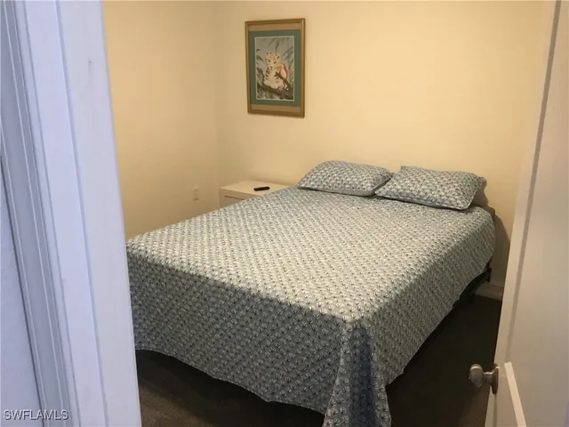 a bedroom with a bed and painting on the wall