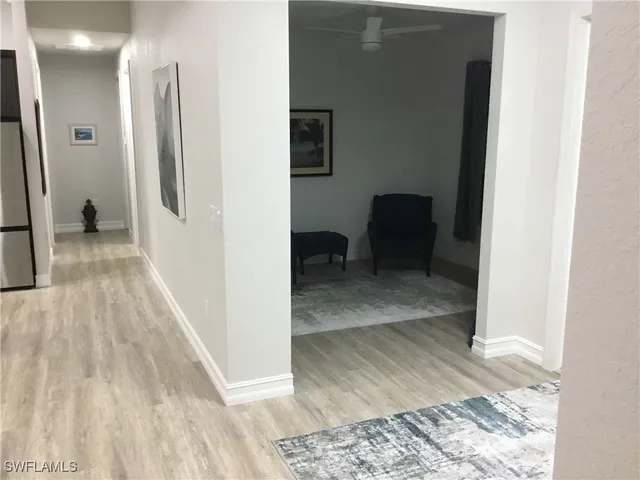 a view of a hallway with wooden floor and furniture