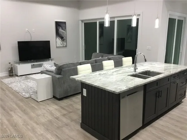 a living room with granite countertop furniture and a flat screen tv