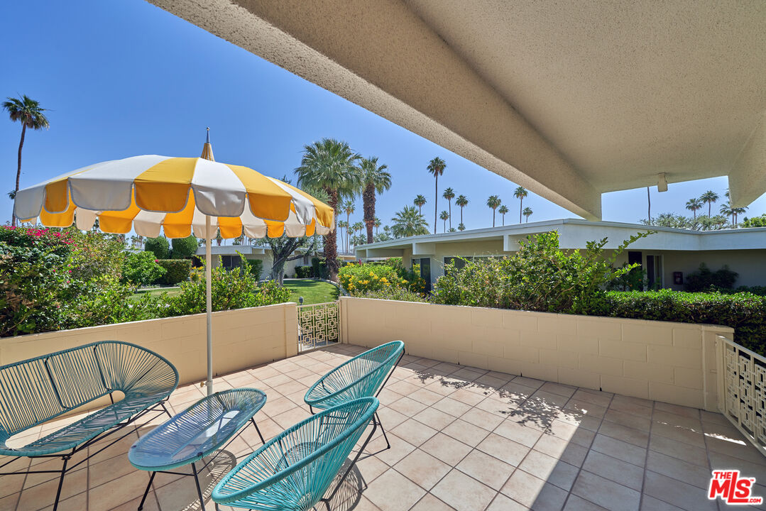 1855 E. Ramon Road, Unit 19 Palm Springs, CA 92264 - Photo 2 of 42 a view of a chairs and table in the backyard
