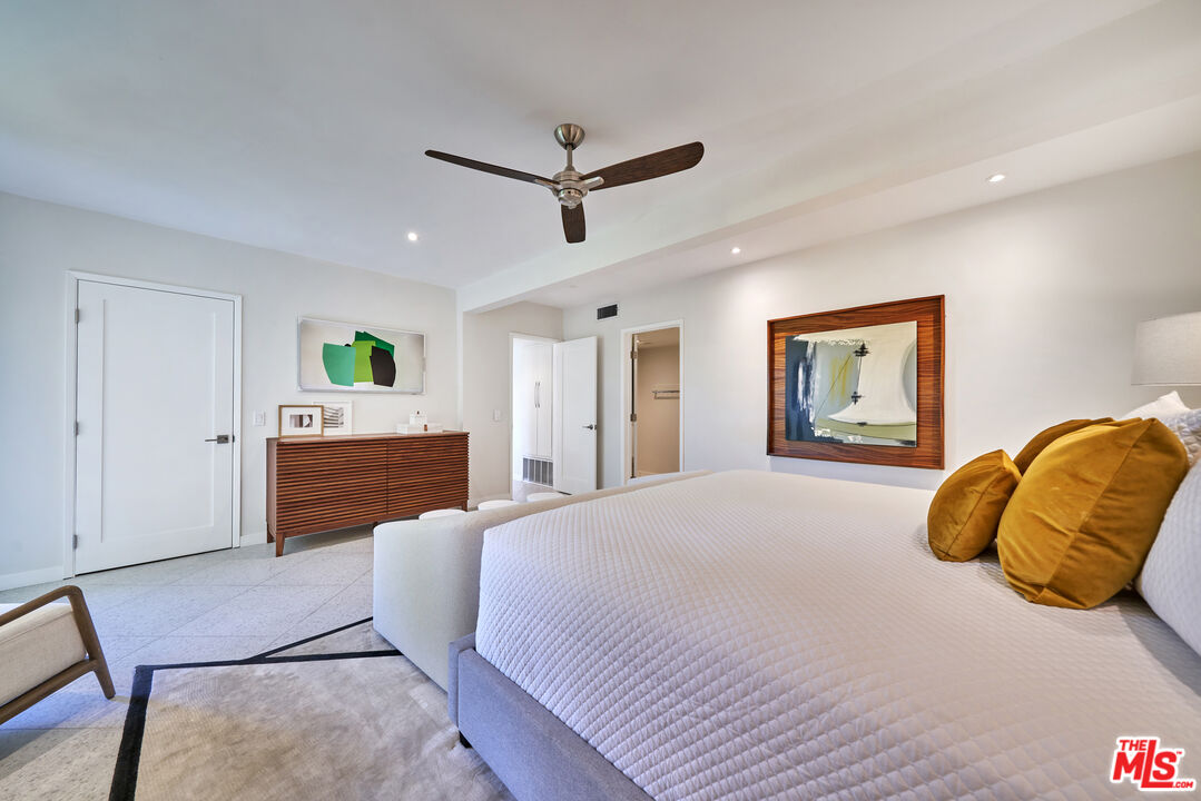 1855 E. Ramon Road, Unit 19 Palm Springs, CA 92264 - Photo 24 of 42 a spacious bedroom with a bed and a chandelier