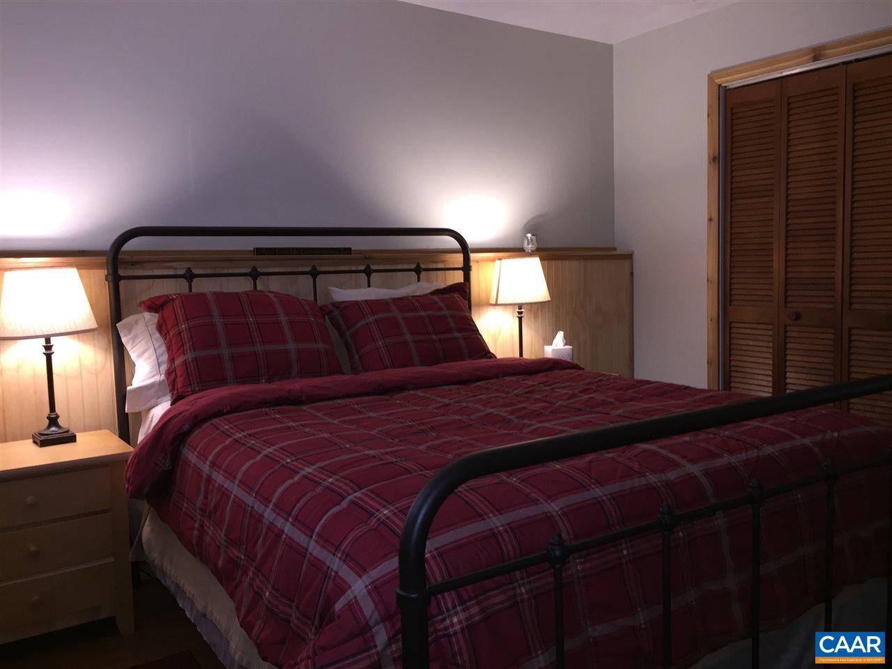 452 Three Ridges, Unit 452 Roseland, VA 22967 - Photo 17 of 28 a bedroom with a bed and a lamp