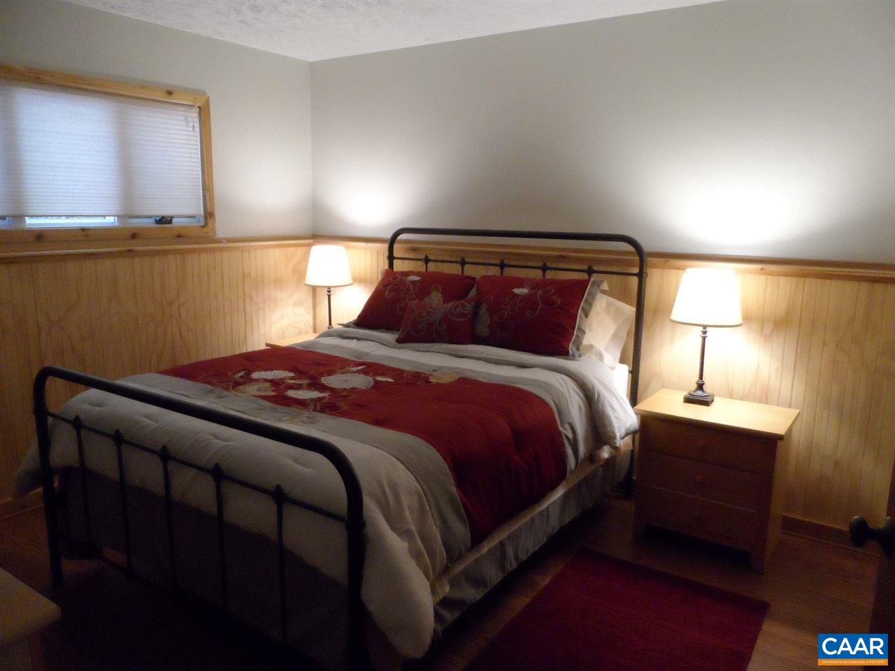 452 Three Ridges, Unit 452 Roseland, VA 22967 - Photo 19 of 28 a bed sitting in a bedroom next to a lamp