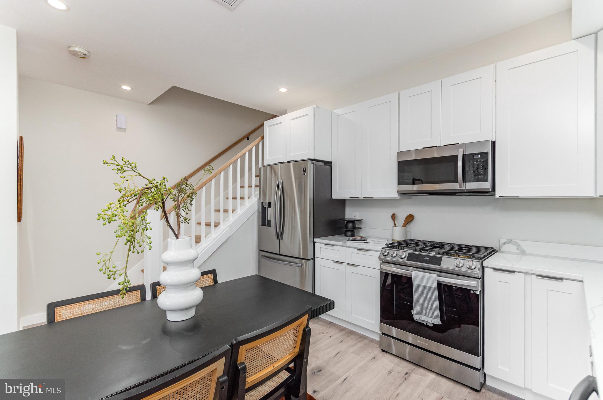2116 4th Street Northeast, Unit B Washington, DC 20002 - Photo 10 of 28 a kitchen with stainless steel appliances a stove a microwave a sink a stove white cabinets and wooden floor