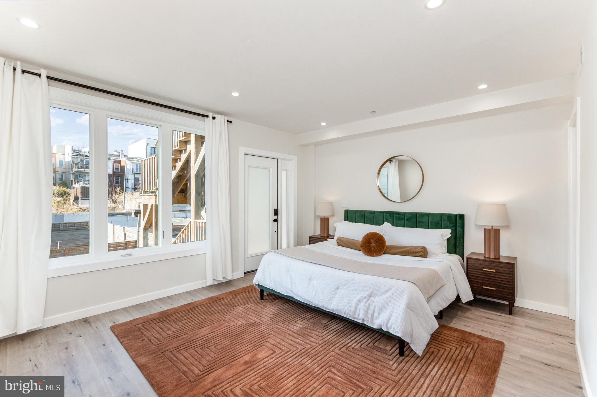 2116 4th Street Northeast, Unit B Washington, DC 20002 - Photo 11 of 28 a bed sitting in a bedroom next to a window