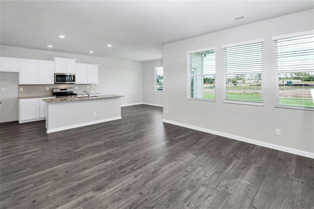 197 Lauritsen Way Newnan, GA 30265 - Photo 18 of 33 a kitchen with stainless steel appliances a stove top oven a sink a refrigerator and a window