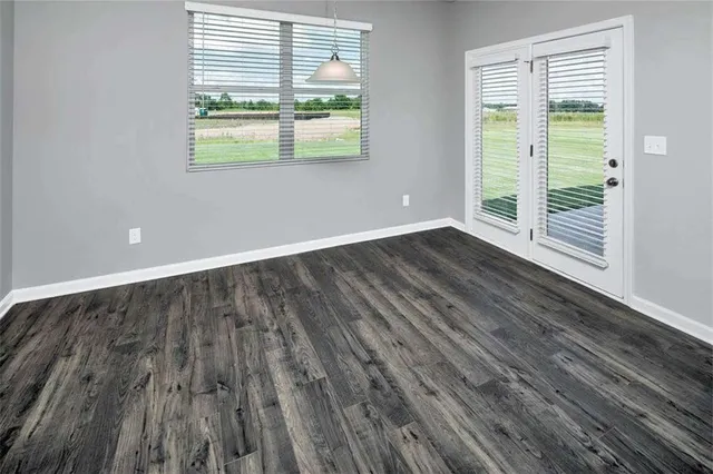 a large kitchen with a lot of counter space and wooden floor