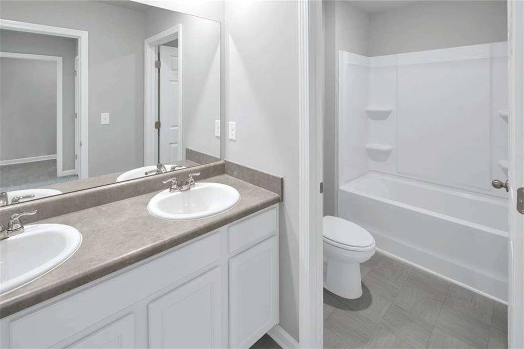 197 Lauritsen Way Newnan, GA 30265 - Photo 26 of 33 a bathroom with a granite countertop sink toilet and shower