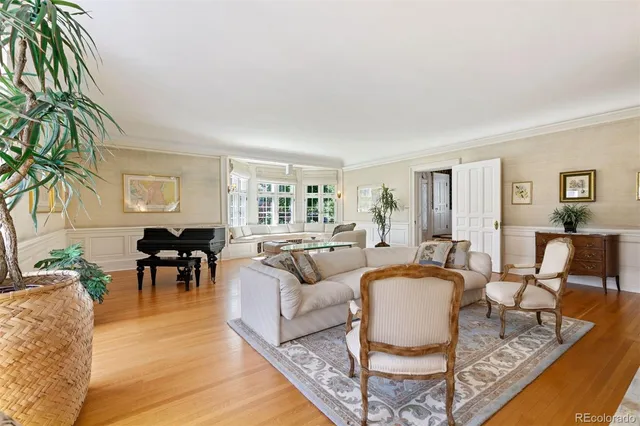 a dining room with wooden floor a chandelier a wooden table and chairs