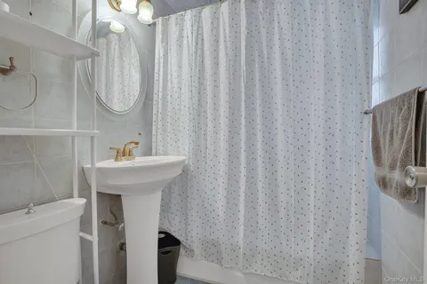 a bathroom with a sink toilet and a mirror