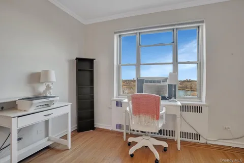 a view of a workspace with furniture and a window