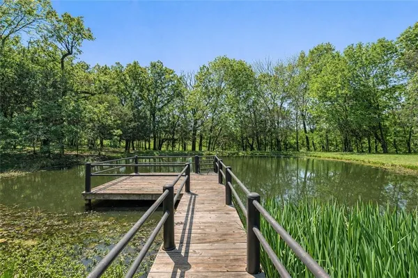 a wooden pier with boats in a lake