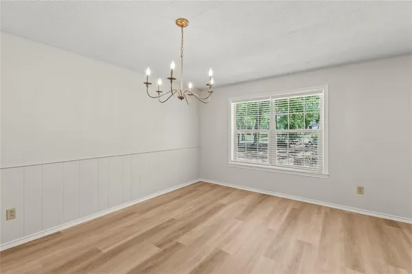 a view of wooden floor chandelier and window in a room