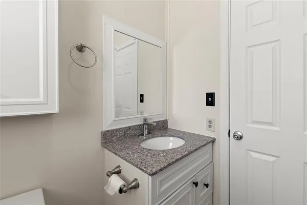 a bathroom with a granite countertop sink and a mirror