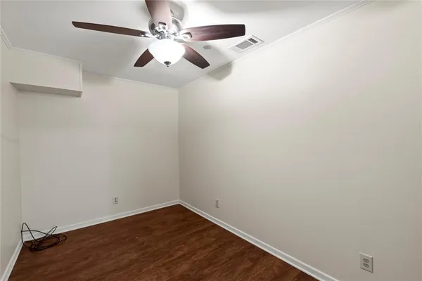 an empty room with a window and ceiling fan