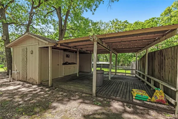 a view of house with wooden floor outdoor seating and covered with green space