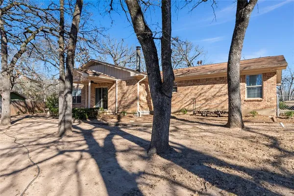 a view of a house with a tree next to a yard