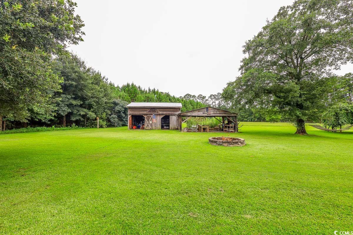 5900 Pope Martin Road Conway, SC 29527 - Photo 2 of 31 View of grassy yard featuring view of scattered trees and an outbuilding