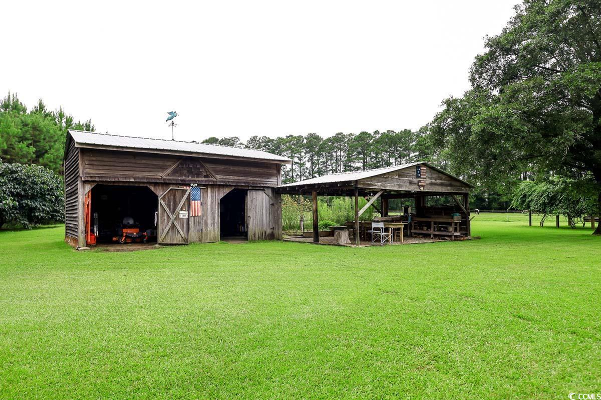 5900 Pope Martin Road Conway, SC 29527 - Photo 26 of 31 View of grassy yard featuring an outbuilding, view of scattered trees, and a barn