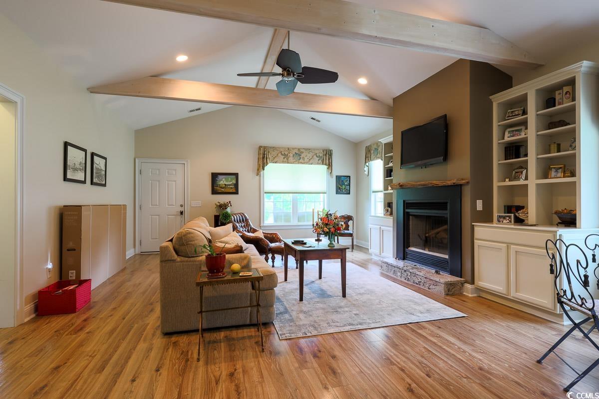5900 Pope Martin Road Conway, SC 29527 - Photo 3 of 31 Living area with beamed ceiling, light wood-style floors, ceiling fan, a fireplace with raised hearth, and built in features