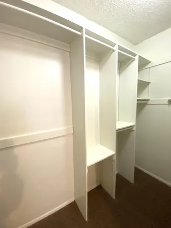 a view of walk in closet with empty racks