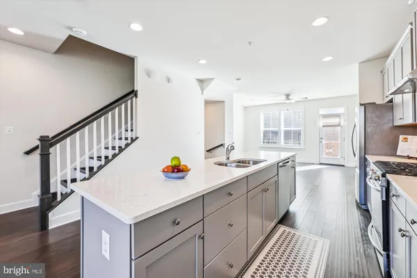 a kitchen with counter top space sink stove and wooden floor