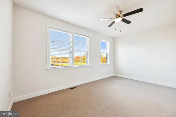 an empty room with a window and a ceiling fan