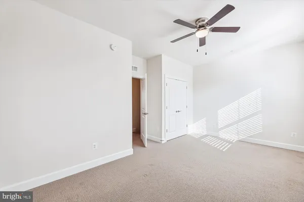 an empty room with a ceiling fan and a window