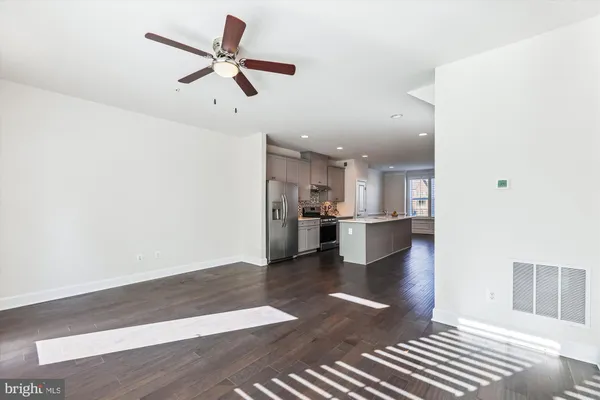 a view of open kitchen with wooden floor and a ceiling fan