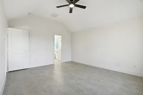 an empty room with a ceiling fan and window