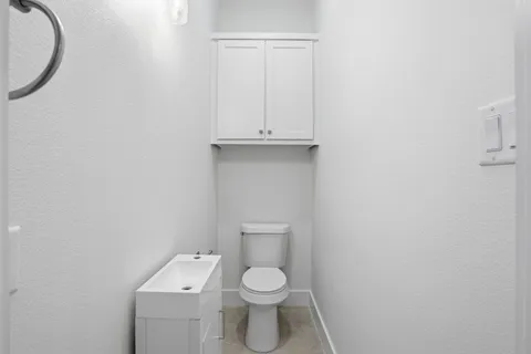 a white toilet sitting next to a white cabinet