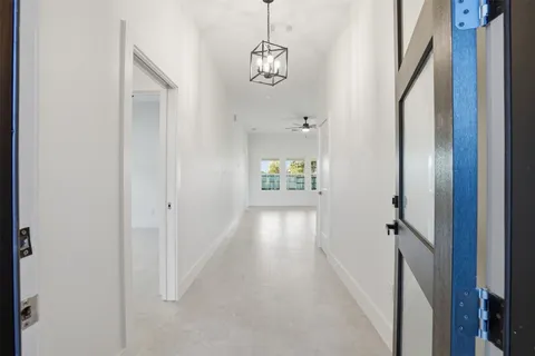 a view of hallway with stairs and wooden floor