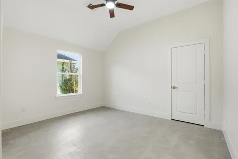 an empty room with windows and fan