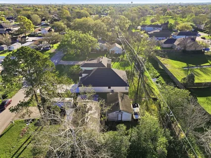an aerial view of residential houses with outdoor space and trees