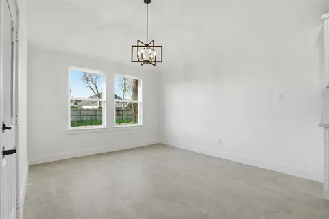 a view of a room with a ceiling fan and windows