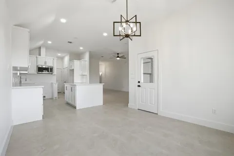 a view of a kitchen with a refrigerator and white cabinets