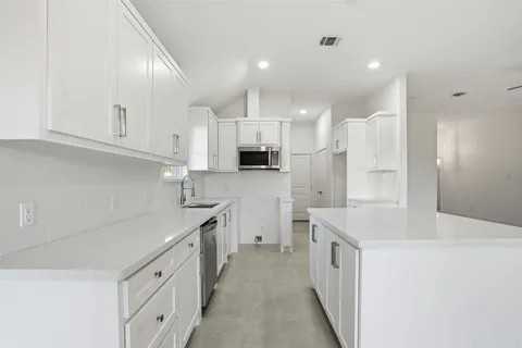 a kitchen with stainless steel appliances white cabinets and a sink